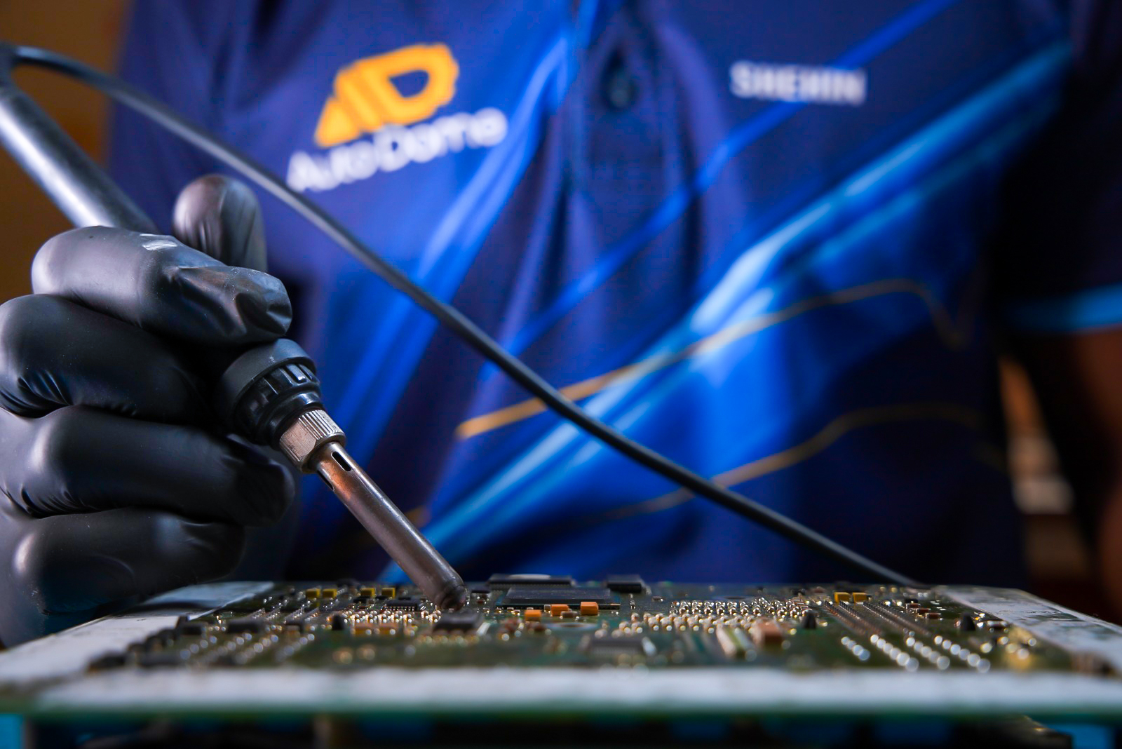 Engineer repairing a vehicle electronic control unit circuit board
